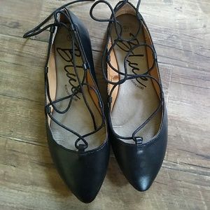 Black lace up flat shoes.